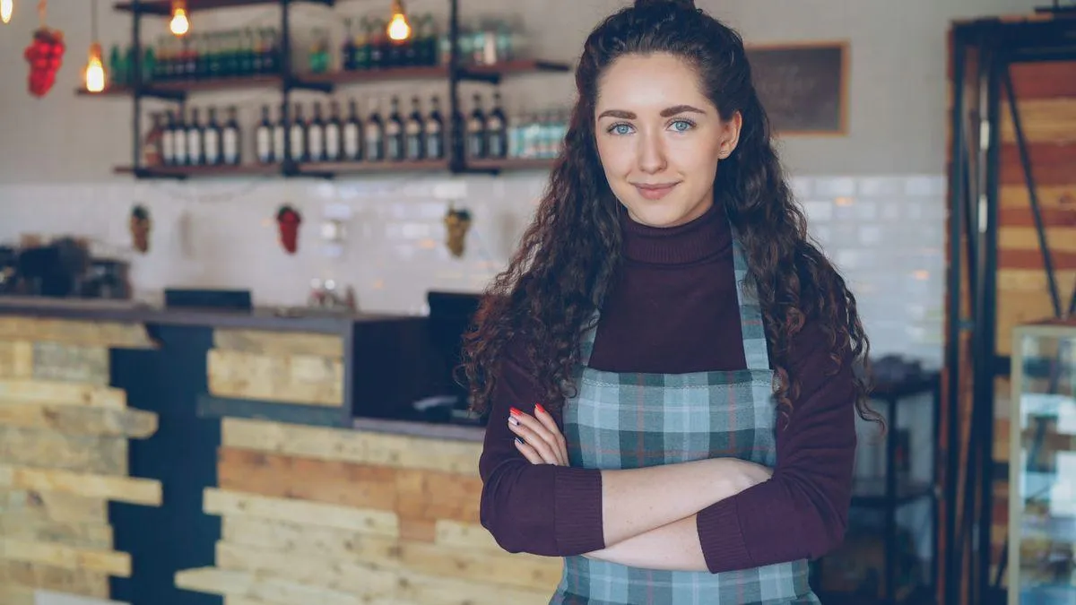 pourquoi angers attire de plus en plus dindependants et de tpe 2 Propriétaire de petit commerce souriante, les bras croisés, dans son atelier-boutique au comptoir en bois